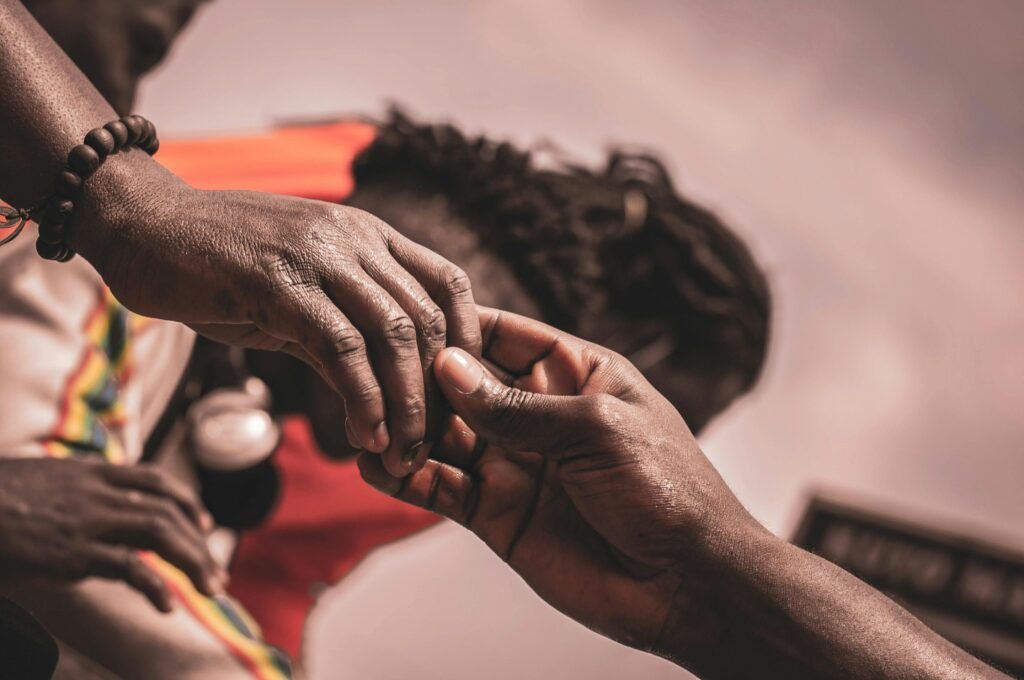 Detailed close-up of hands interacting outdoors, with a blurred background suggesting connection.