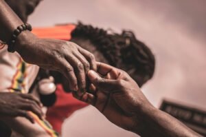 Detailed close-up of hands interacting outdoors, with a blurred background suggesting connection.